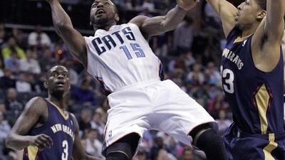 Charlotte Bobcats' Kemba Walker, left, gets his shot off despite being fouled by New Orleans Pelicans' Anthony Davis during the second half of an NBA basketball game in Charlotte, N.C. on Friday, February. 21, 2014. The Bobcats won 90-87. AP Photo/Bob Leverone