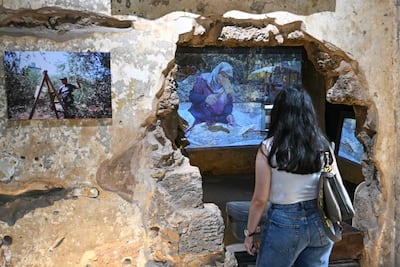 A visitor watches footage documenting everyday life in southern Lebanon, presented within Beit Beirut’s war-scarred interiors as part of Hkeeli Ya Jnoub’s wider exploration of memory, place and loss. AFP