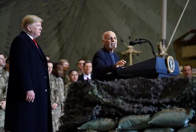 Afghan's President Ashraf Ghani speaks to US soldiers as Mr Trump listens. AFP