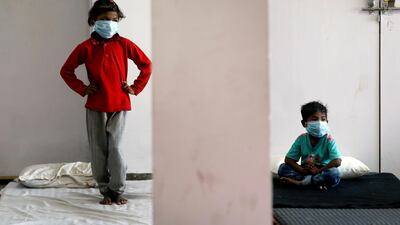 Children of migrant workers wear protective masks inside a sports complex turned into a shelter, during a 21-day nationwide lockdown to slow the spread of the coronavirus disease (COVID-19), in New Delhi, India. REUTERS