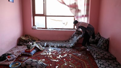 An Afghan man removes broken glass after a suicide bomb blast in Kabul, Afghanistan. Reuters