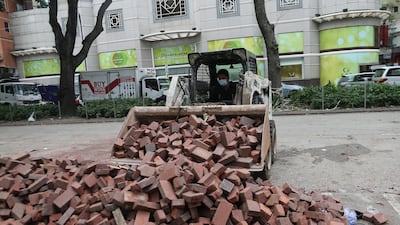 Clean up crews clean the street the day after clashes between protesters and police in Tsim Sha Tsui near the Polytechnic University, in Hong Kong. EPA