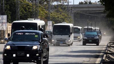 Pakistani security officials escort the Australian team for a practice session in Rawalpindi. EPA
