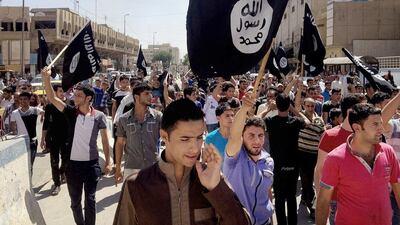 Demonstrators chant pro-ISIL slogans as they carry the group's flags. Seeking the assistance of the Syrian regime in fighting ISIL is dangerous and morally indefensible, says Faisal Al Yafai (AP Photo, File)