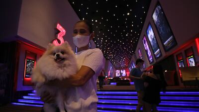 People with their pets walk arrive at the cinema on its opening day. EPA