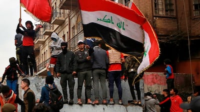 Anti-government protesters gather on barriers set up by security forces to close Rasheed Street during ongoing protests in Baghdad. AP Photo