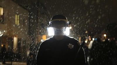 A police officer in San Francisco faces protesters angry about the grand jury's decision on the shooting of Michael Brown in Missouri. Photo: Elijah Nouvelage / Reuters