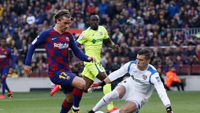Antoine Griezmann, left, scores past Getafe's goalkeeper David Soria on Saturday. AP