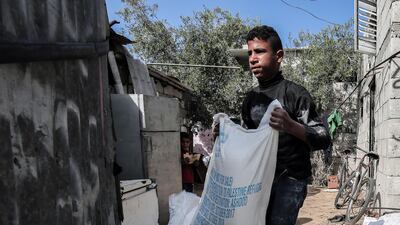 A Palestinian man delivers food aid provided by the UN agency for Palestinian refugees to a family in the Rafah refugee camp in the southern Gaza Strip on January 24, 2018. Said Khatib / AFP