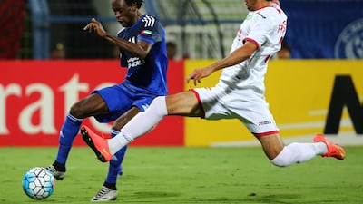 Jonathan Pitroipa (L) of UAE's Al-Nasr club dribbles the ball as Sherzod Fayziev of Uzbekistan's Lokomotiv club tackles during their Asian Champions League (AFC) group A football match at the Rashid Al-Maktoum Stadium in Dubai on April 20, 2016. The match ended in a 1-1 draw. / AFP / MARWAN NAAMANI