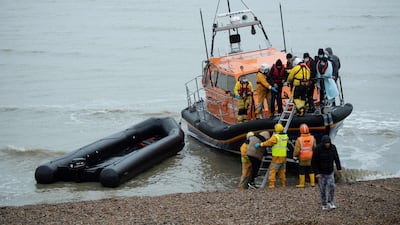 Migrants are helped ashore from a lifeboat at a beach in Dungeness, south-east England, after being rescued while crossing the English Channel. AFP