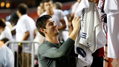 Real Madrid goalkeeper Thibaut Courtois signs autographs for fans in the stands. Reuters
