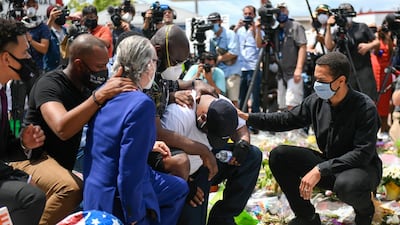 Terrence Floyd, wearing white T-shirt, kneels at a makeshift memorial for his brother, George Floyd, near the intersection of 38th and Chicago in front of the Cup Foods at the spot where he was arrested and died in police custody, in Minneapolis, Minnesota, US. EPA