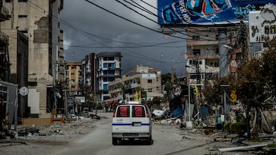 Medics in Nabatieh drive past rubble and buildings damaged by Israeli strikes. Getty Images