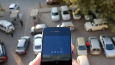 The Uber smartphone app, used by customers to book taxis using its service, is pictured over a parking lot in the Indian capital New Delhi. Tengku Bahar/ AFP