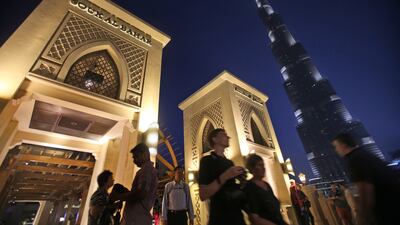 With the world tallest tower, Burj Khalifa, in background, tourists cross a bridge to Souk Al Bahar in Dubai. Overseas visitors spend far more in the city than in 11 global peers surveyed by Savills. Kamran Jebreili / AP