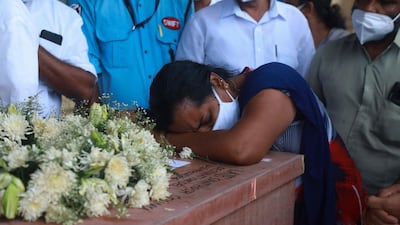 A relative mourns over a coffin with the remains of Soumya Santosh, a native of Idukki who was killed in a rocket attack in Israel during the deadly fire between Palestinian militants in Gaza and the Israel's army, at Kochi International Airport in Kochi, India. AFP