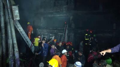 Firefighters and local people gather near smoldering buildings in Dhaka, Bangladesh. AP Photo