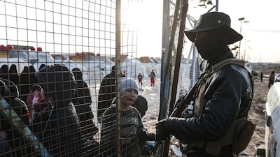 Syrian security forces stand guard along the fence of Al Hol camp in January. AFP