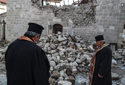 Priests in the Altinozu district of Hatay, southern Turkey stand in the ruins of the Virgin Mary Greek Orthodox church. According to the UN, more than 3,700 of the 8,444 structures categorised as cultural heritage by the Turkish state were damaged or destroyed as a result of last year's earthquakes. EPA