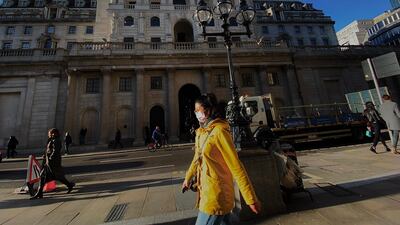 A pedestrian, wearing a protective face mask, walks past the Bank of England in the City of London. The Bank of England slashed its interest rate to a record low 0.25 per cent on Wednesday as part of coordinated emergency action with the UK government to combat the economic fallout from the coronavirus outbreak. AFP