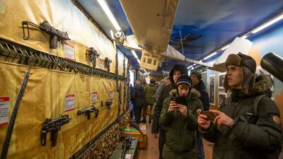 Visitors look at weapons and drones on display. AP Photo