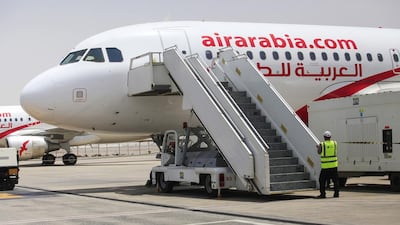 RAS AL KHAIMAH, UAE. July 7, 2014 - Stock Photograph of workers on the tarmac in front of an Air Arabia plane at Ras Al Khaimah International Airport in Ras Al Khaimah, July 7, 2014. (Photos by: Sarah Dea/The National, Story by: Shereen El Gazzar, Business)