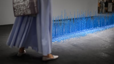 A visitor walks past a 'rainfall' artwork by Moroccan-French visual artist Latifa Echakhch on display at the modern and contemporary art fair in Basel. AFP