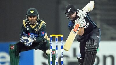 New Zealand captain Kane Williamson, right, plays a shot as Pakistani wicketkeeper Sarfraz Ahmed looks on during the second one-day international cricket match at the Sharjah cricket stadium on December 12, 2014. Aamir Qureshi / AFP