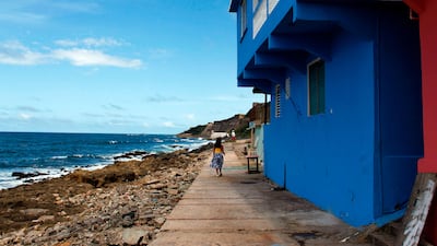 A woman walks in the neighbourhood of La Perla in San Juan. Ricardo Arduengo / AFP