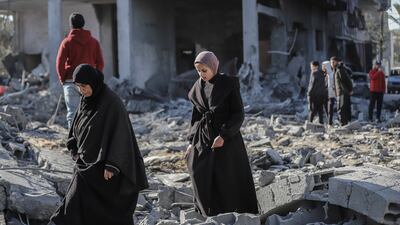 Palestinians walk across building debris following an Israeli air strike at the Nuseirat refugee camp in central Gaza. Bloomberg