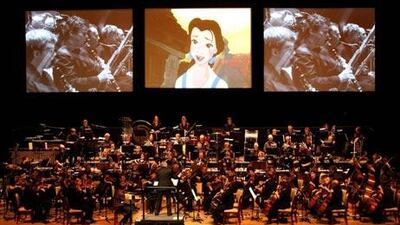Clips from 'Beauty and the Beast' are shown on a giant screen as the London Philharmonia Orchestra plays music from the film during ' The Magical Music of Walt Disney' concert last night.