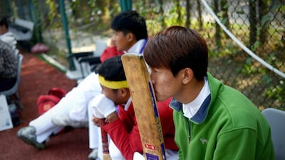 Chinese cricketers, above, watching a match played on an AstroTurf pitch in Beijing. Wang Zhao / AFP