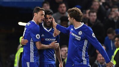 Diego Costa celebrates with Nemanja Matic, left, and Marcos Alonso after scoring Chelsea’s fourth goal. Justin Tallis / AFP