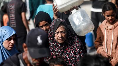 Palestinians, including children, fill and carry water distributed by a water tanker into containers in port area of Gaza city on May 27