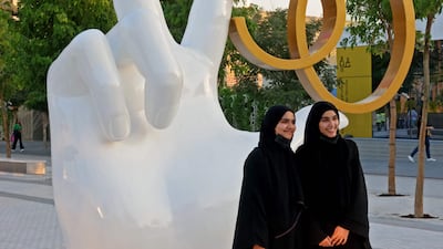 Two visitors pose for pictures at Expo 2020. AFP