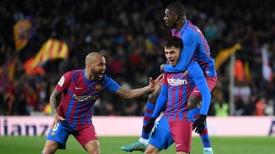 Pedri celebrates with Ousmane Dembele and Dani Alves after scoring for Barcelona against Sevilla at the Camp Nou stadium in Barcelona on April 3, 2022. AFP