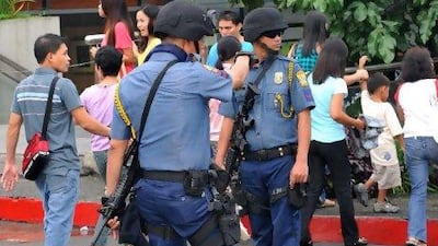 Heavily armed police officers secure a shopping centre in Manila yesterday following warnings of possible terror attacks.