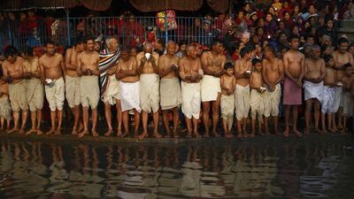 Devotees offer prayer as they stand on the bank of the Hanumante River, during the final day of the month-long Swasthani festival, at Bhaktapur, near Kathmandu.