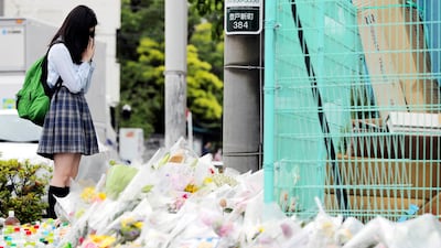 A schoolgirl prays at the site of a mass stabbing in the Japanese town of Kawasaki. A number of pupils from Caritas Elementary School were among the victims. One child and one adult were killed in the attack EPA