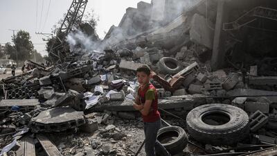 A Palestinian boy stands amidst the rubble. AFP