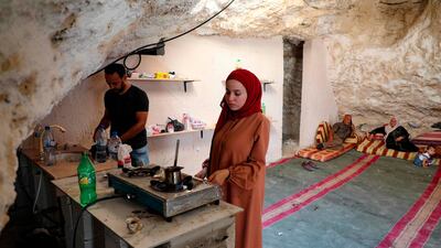 Ahmed Amarneh and his wife prepare coffee in the kitchen of his cave home. AFP