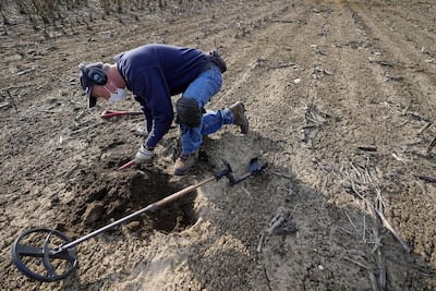 Metal detectorist Jim Bailey searches for Colonial-era artefacts in a field. AP