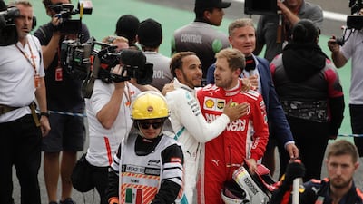 Lewis Hamilton is congratulated by Sebastian Vettel. EPA