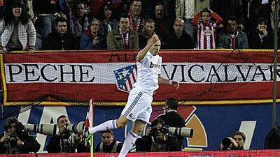 Real Madrid's in-from striker Karim Benzema celebrates his goal in front of Atletico fans.
