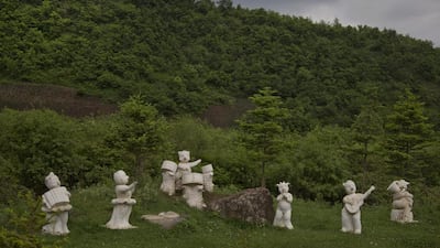 Statues of animals playing musical instruments stand along the roadside south of Samsu, North Korea in Ryanggang province.
