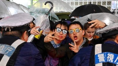People gesture standing on the streets under the rain as the new era of Japan's emperor called the Reiwa Era begins, and the Heisei Era ends, in Shibuya district in Tokyo. Japan's new emperor Crown Prince Naruhito faces the delicate task of balancing tradition within the world's oldest monarchy and his own modern values, including protecting his family from the palace's rigid rules AFP