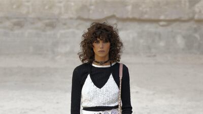 Flowers are embroidered across high-waisted trousers, worn here with a crochet bralet. Courtesy Chanel