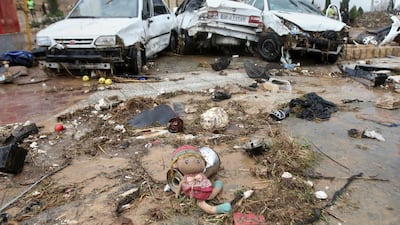 A child's doll lies in front of destroyed cars after a flash flood in the southern city of Shiraz. AP Photo