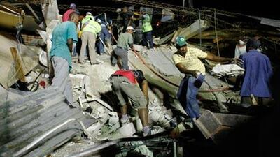 Port-au-Prince residents help rescuers search through the rubble for survivors and bodies in the aftermath of the 7.0 magnitude earthquake in Haiti.